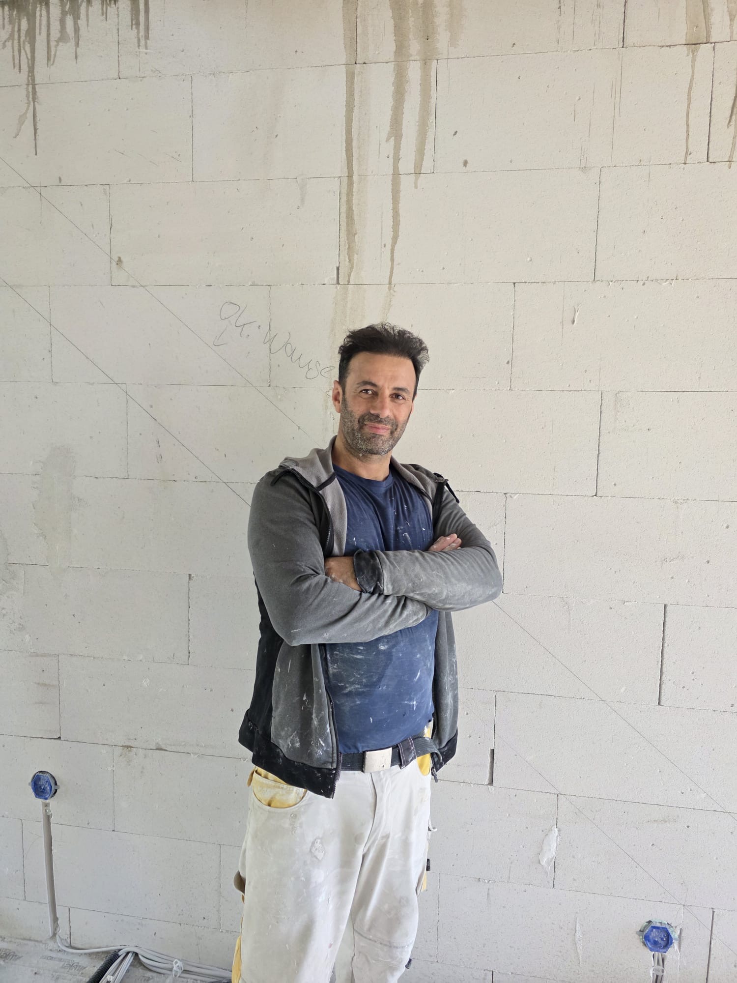 Ayhan Demirtas auf der Baustelle vor einer Wand